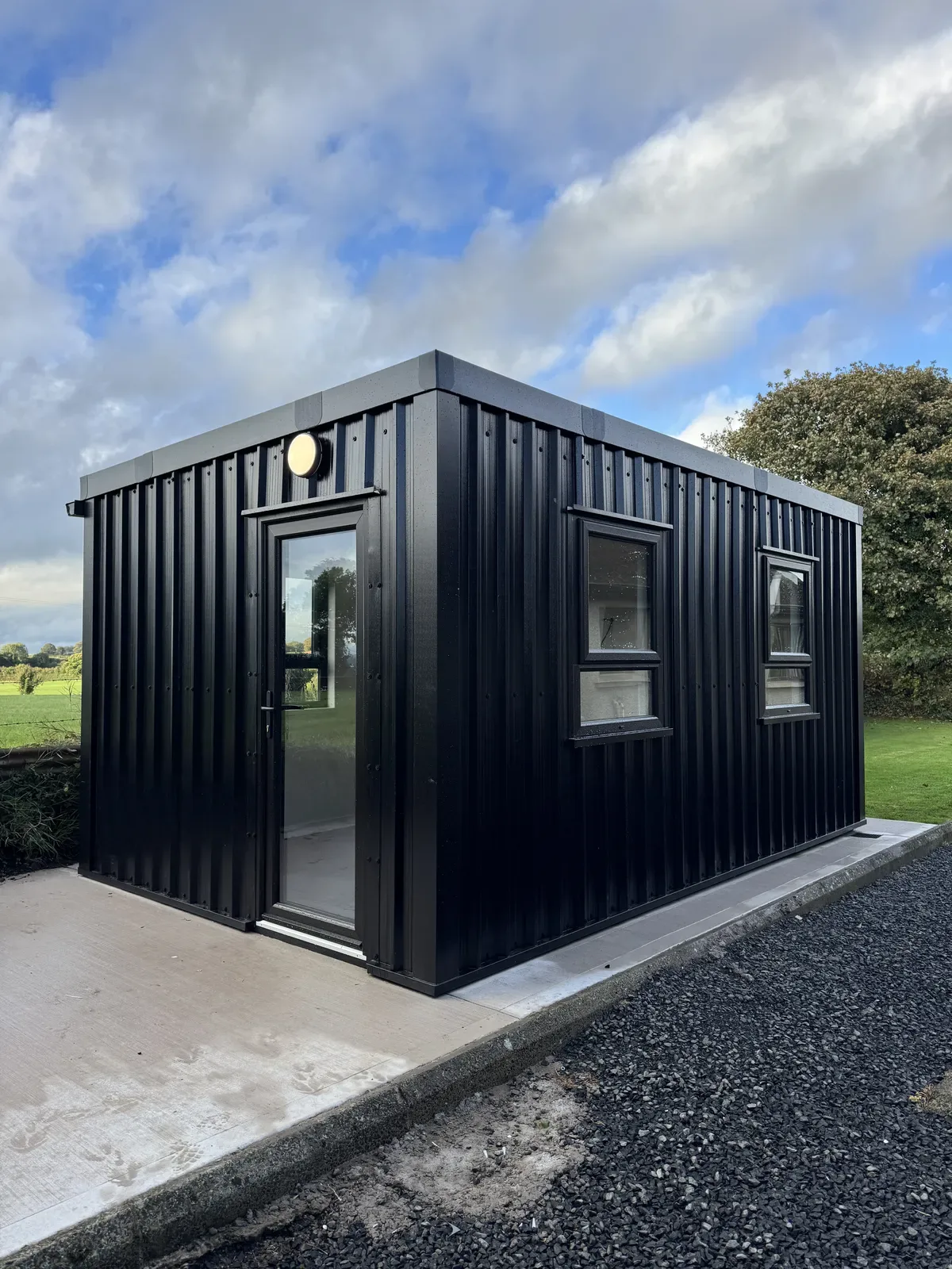Black steel-clad garden room on a concrete base